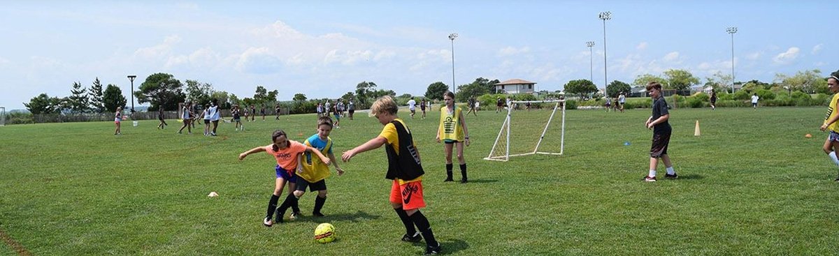 Kids playing soccer in a soccer field